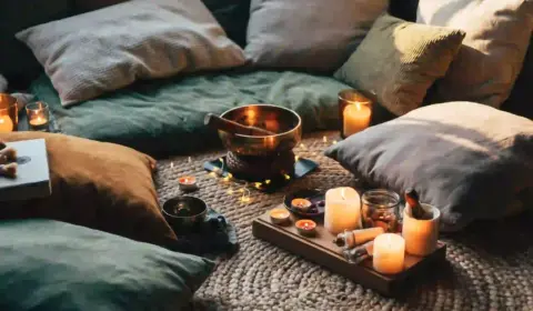 Gemütliche Yogaecke mit Kissen, Klangschale, Lichtern und Kerzen
