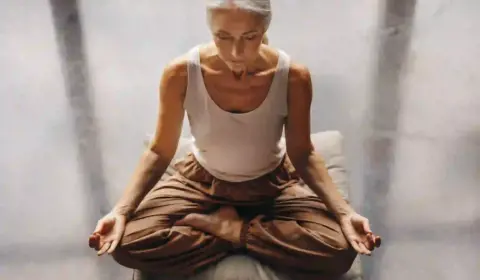 Frau in der Menopause sitzt im Meditationssitz