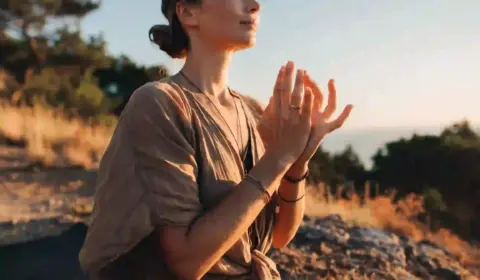 Frau ist dankbar und hält ihre Finger in einem Mudra