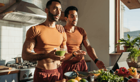 Zwei Sportler in der Küche vor Gemüse