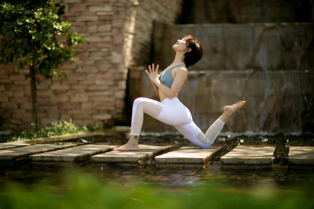 Frau macht draußen im Frühling Yoga