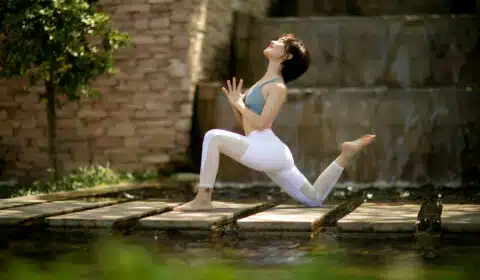 Frau macht draußen im Frühling Yoga