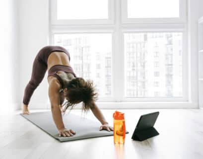 Frauc macht Yoga mit einer Yoga App