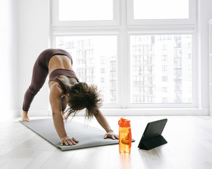 Frauc macht Yoga mit einer Yoga App