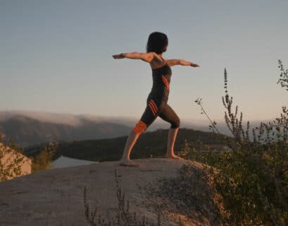 Frau macht Yoga Übungen für Radfahrer draussen in der Natur auf einem Berg