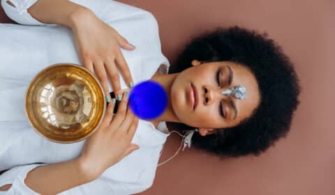 Frau liegt auf dem Rücken und macht eine Halschakra Meditation