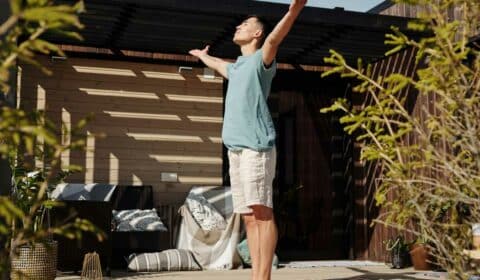Mann macht Sonnengrüße draußen auf der Terrasse