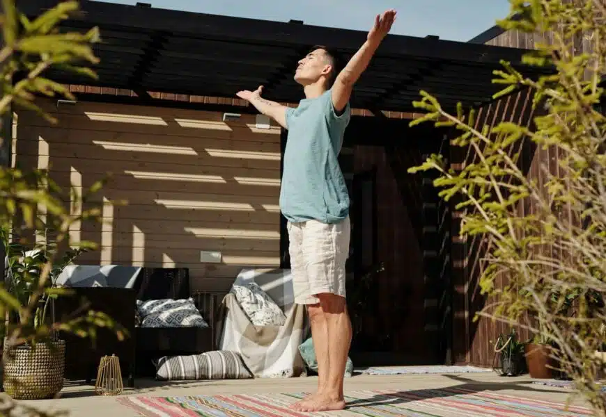 Mann macht Sonnengrüße draußen auf der Terrasse