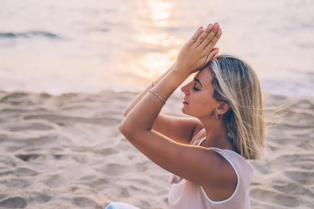Frau macht Yoga am Meer
