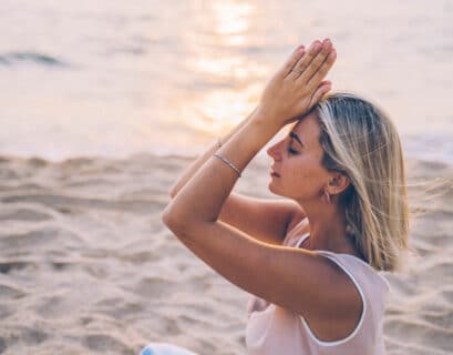 Frau macht Yoga am Meer