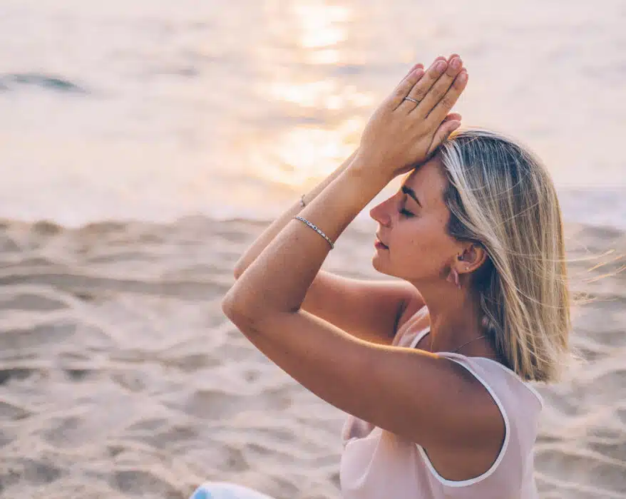 Frau macht Yoga am Meer