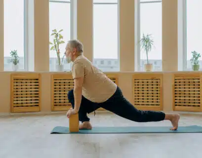 Senior macht Yoga mit seiner Krankheit Arthritis