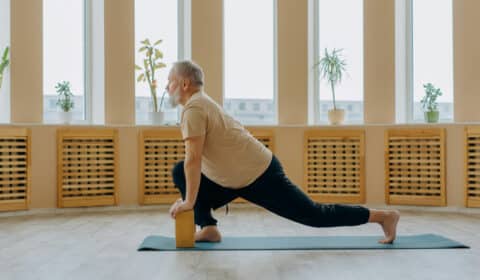 Senior macht Yoga mit seiner Krankheit Arthritis