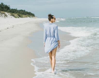 Frau geht am Strand von Trzesacz an der Ostsee spazieren
