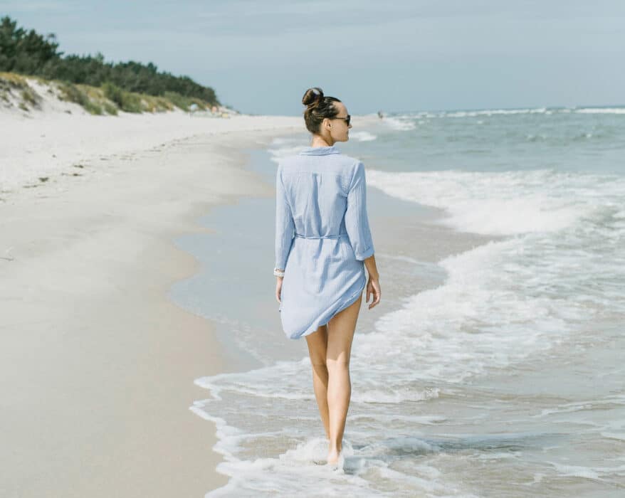 Frau geht am Strand von Trzesacz an der Ostsee spazieren