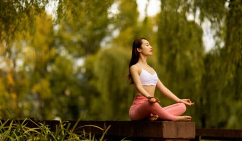 Frau macht alleine Meditation auf einer Ayurveda Reise