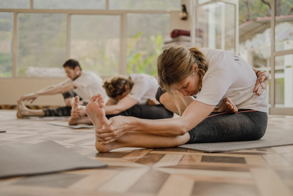 Frau macht Yogaübung auf einer Yogamatte