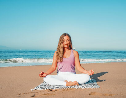 Frau macht Yoga am Strand von Dänemark