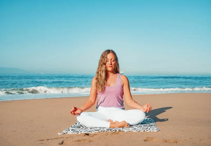 Frau macht Yoga am Strand von Dänemark