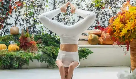 Frau macht die Yoga Übung Kopfstand um ihr Immunsystem zu stärken