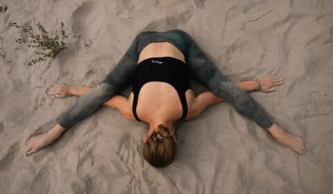 Frau macht Yoga Nidra am Strand