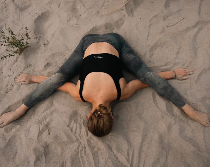 Frau macht Yoga Nidra am Strand