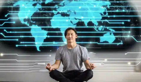 Mann sitzt auf dem Boden und atmet und meditiert vpr einer digital Leinwand