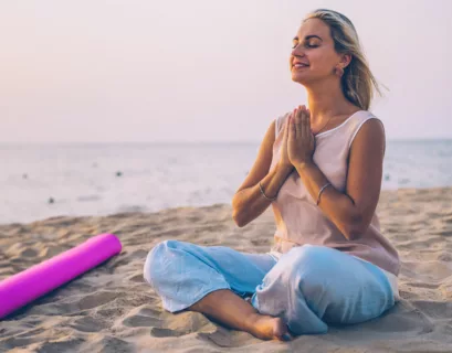 Frau macht Yoga am Strand