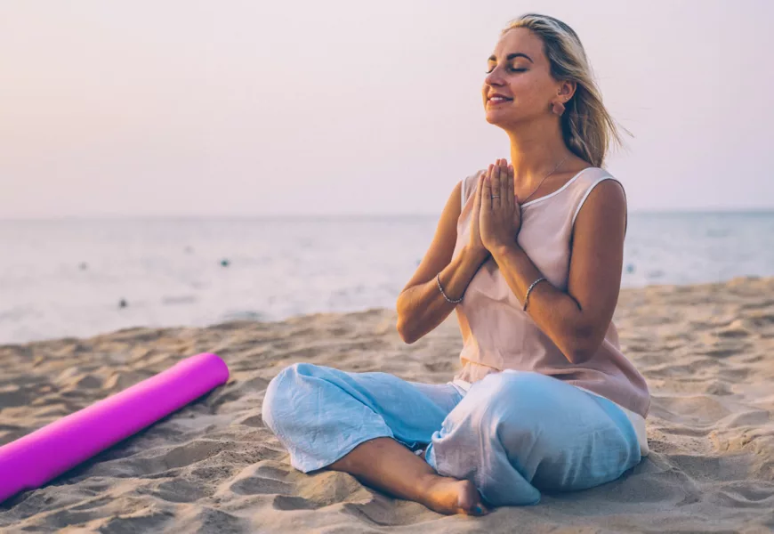 Frau macht Yoga am Strand