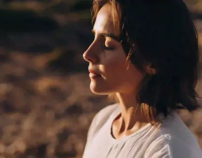 Frau hat die Augen geschlossen und atmet bewusst