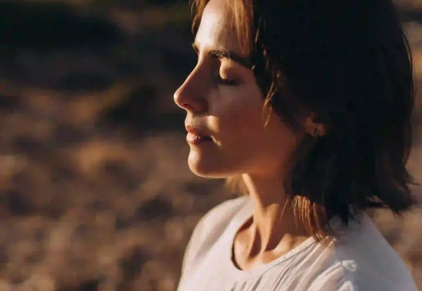 Frau hat die Augen geschlossen und atmet bewusst