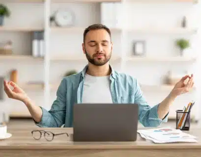 Mann macht Yogaübungen gegen Stress am Schreibtisch