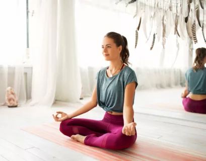 Frau sitzt auf dem Boden im Meditationssitz