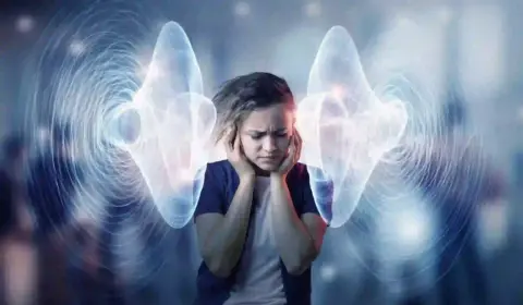 Frau hält sich die Ohren