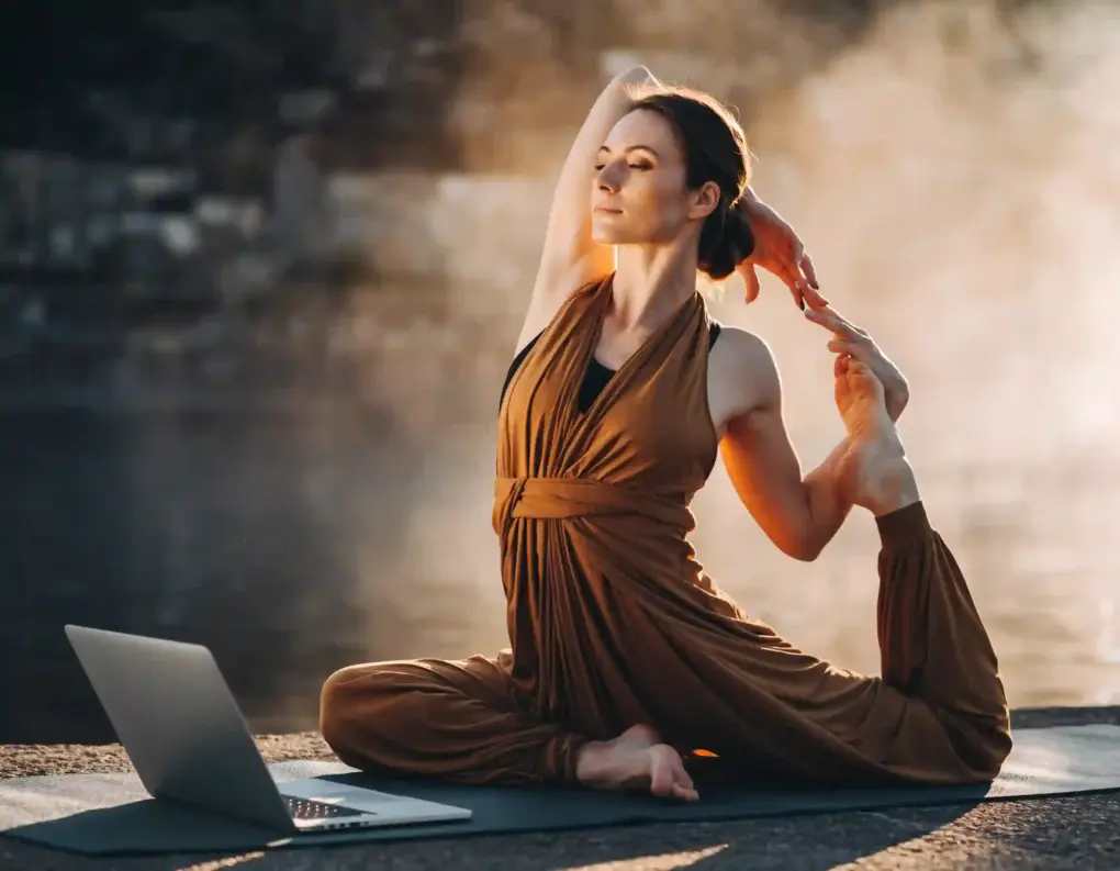 Frau macht Yoga vor ihrem Laptop
