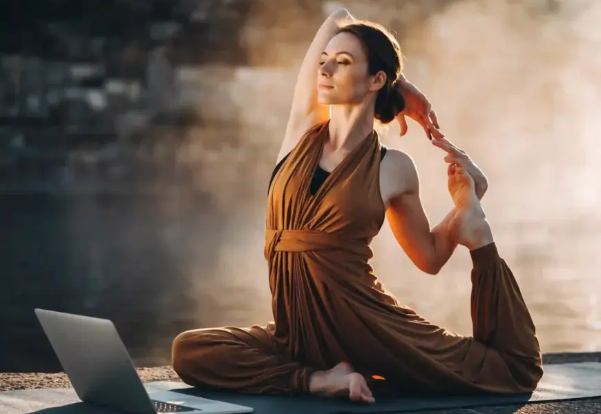 Frau macht Yoga vor ihrem Laptop