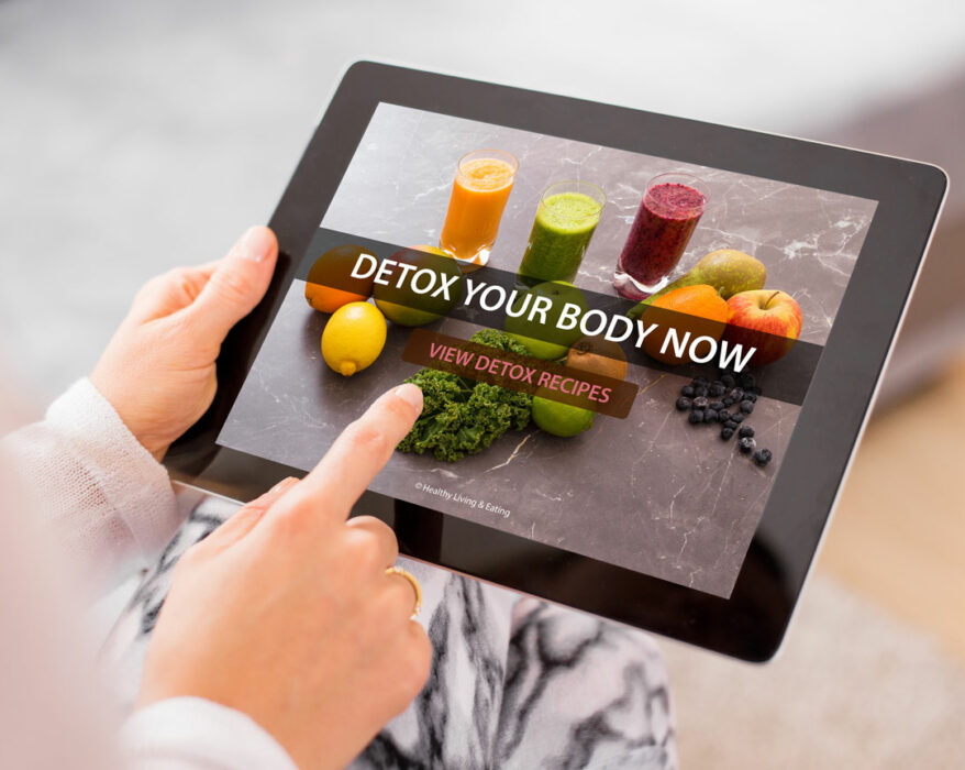 Frau hält Tablet mit dem Slogan „DETOX YOUR BODY NOW"