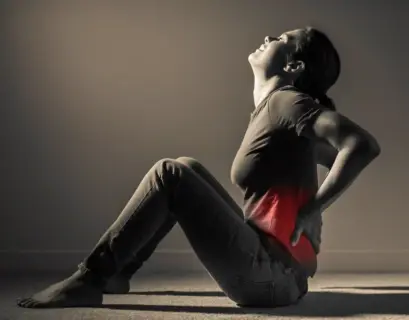 Frau hält sich ihren schmerzenden Rücken