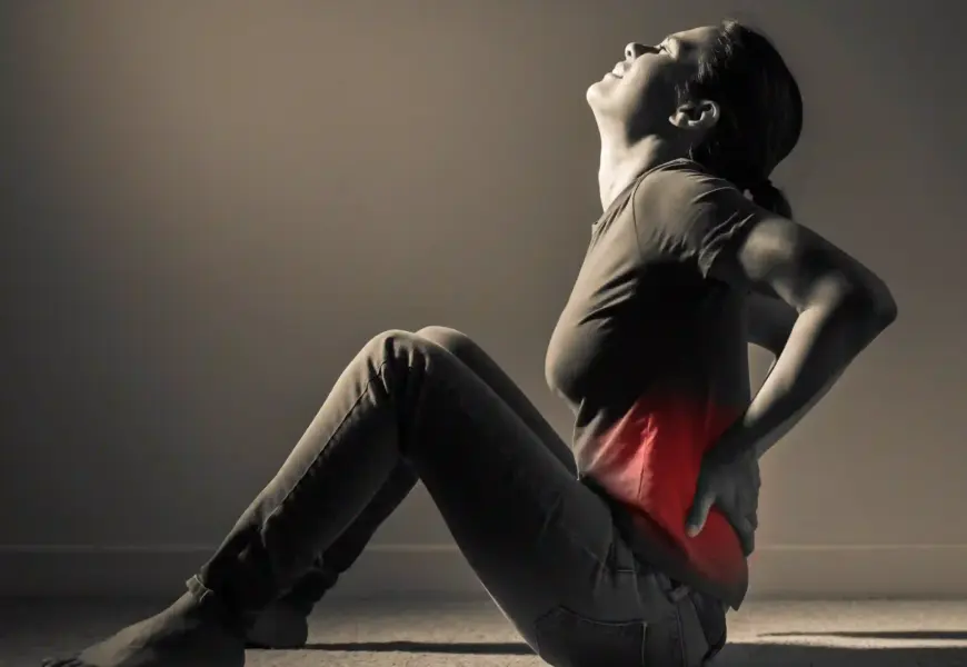 Frau hält sich ihren schmerzenden Rücken