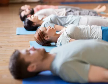 Gruppe von Menschen macht Yoga-Übungen bei Tinnitus im Studio