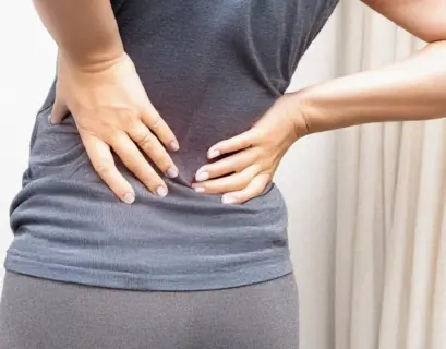 Frau hält sich ihren schmerzen Rücken