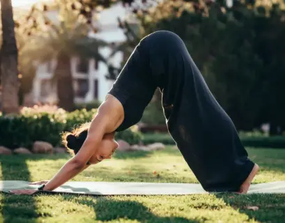 Frau macht düe Yogaübung der Herabschauende Hund gegen Rückenschmerzen