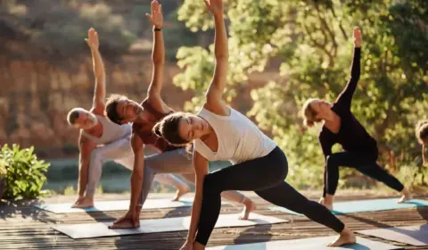 Yoginis machen draußen Yoga