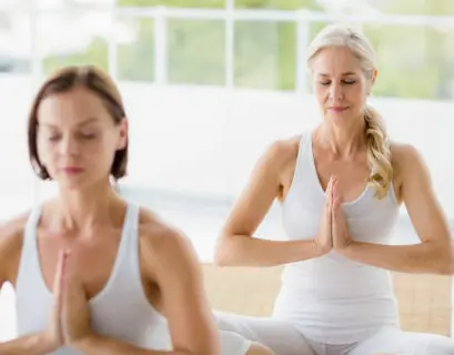 Frau in der Menopause sitzt und meditiert