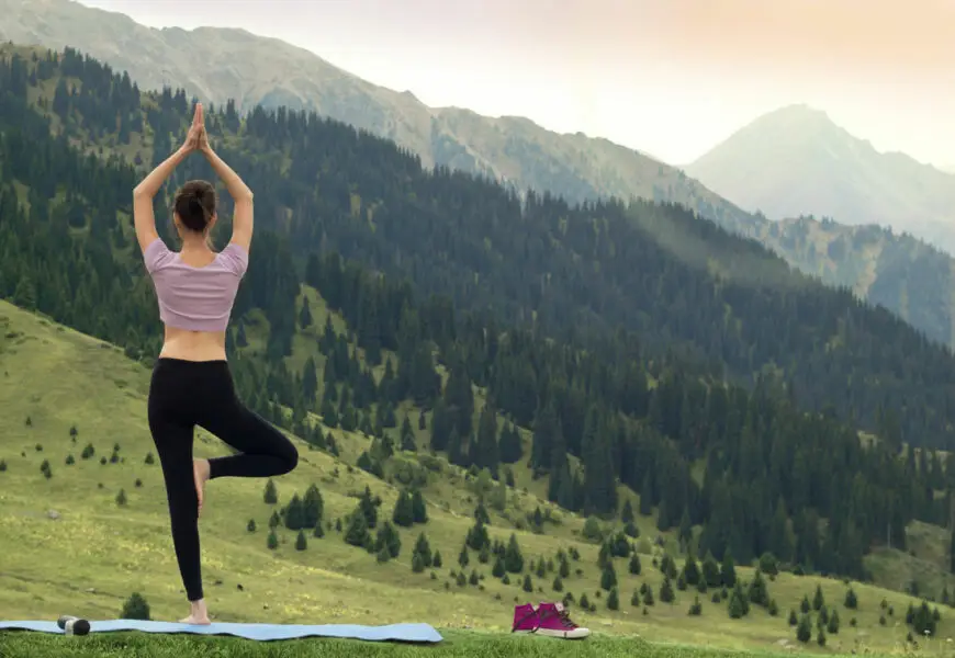 Frau macht Yoga im Freien mit Blick auf die Berge