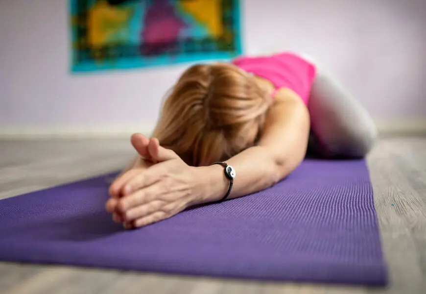 Frau liegt auf der Yogamatte und macht Yin Yoga Übungen