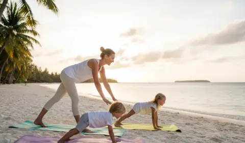 Mutter macht Yoga mit zwei Kindern im Urlaub