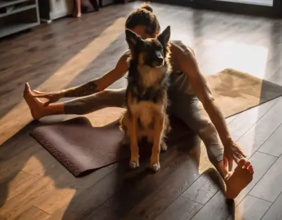Frau macht Doga Yoga mit ihrem Hund