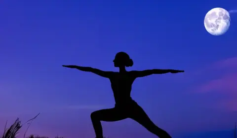 Frau macht Yoga am Vollmond