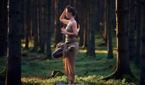 Frau macht die Yogaübung der Baum im Schwarzwald